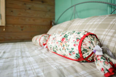 A hotel room with a bed, beautiful pillows. Country hotel, guest house. Selective focusの写真素材