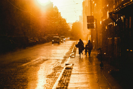 Rainfall, storm in the city. Puddles, people in the rain, sunset. Defocusedの写真素材