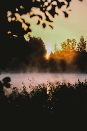 Very beautiful sunrise in summer over a foggy lake. Early morning in summer in nature. Defocusedの写真素材