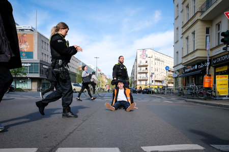 Berlin, Germany - April 24, 2023: Protesters from the group Last Generation sitting on the street and blocking traffic in Berlin, Hermannplatzのeditorial素材