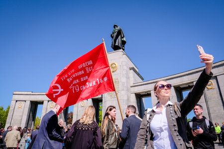 Berlin, Germany - May 9, 2023: Crowd of people with Russian and Soviet flags at Soviet War Memorial...