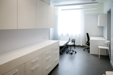A doctors office with a couch and a chair to examine a patients healthの写真素材