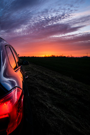 Very beautiful colorful sunset, highway and car. Sunset trip.