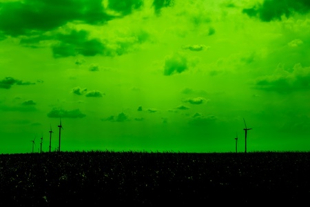 Silhouettes Of Wind Turbines On A Green Skyの写真素材