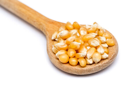 Wooden Spoon With Corn Seeds On Whiteの写真素材