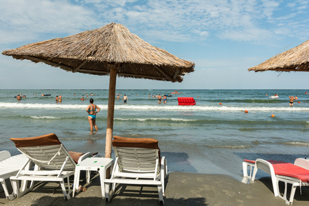 MAMAIA, ROMANIA - JULY 29, 2014: Straw Umbrella And Davenports On Mamaia Beach At The Black Sea.のeditorial素材