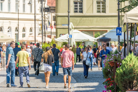 SIBIU, ROMANIA - AUGUST 19, 2014: Tourists Walking Downtown On Nicolae Balcescu Street In The Old Center Of Sibiu.のeditorial素材