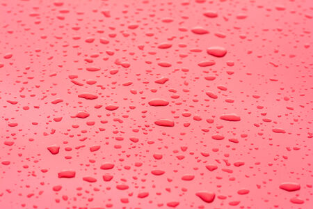Rain Drops Close Up On Red Metallic Surface