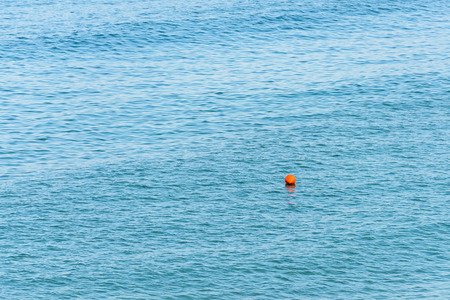 Orange Life Buoy Floating In The Middle Of The Oceanの写真素材