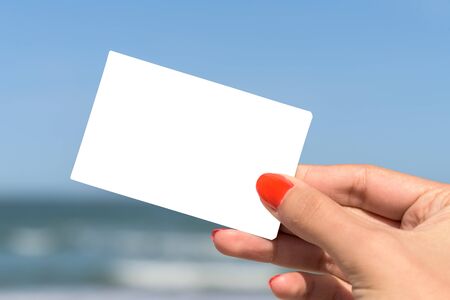 Girl Hand Holding Blank White Card On Beach In Summerの写真素材