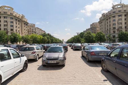 BUCHAREST, ROMANIA - JULY 26, 2015: Cars In Car Parking Lot In Front Of Parliament Palace Casa Poporului Or House Of The People In Bucharest.のeditorial素材