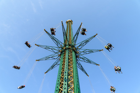 People Having Fun In Carousel Swing Ride At Amusement Parkの写真素材
