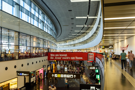 VIENNA, AUSTRIA - AUGUST 12, 2015: People Walking Inside The Terminal Of Vienna International Airport built in 1938, Country's Biggest Airport That Serves As The Hub For Austrian Airlines and Niki.のeditorial素材