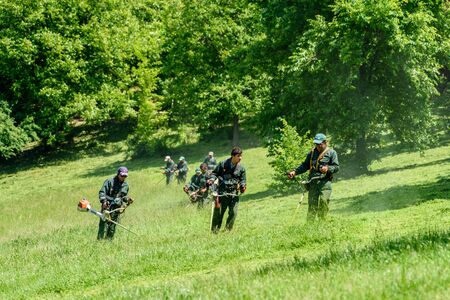 BUCHAREST, ROMANIA - MAY 19, 2016: Workers Mowing The Grass In Springtime In Youths Public Park (Tineretului Park).のeditorial素材
