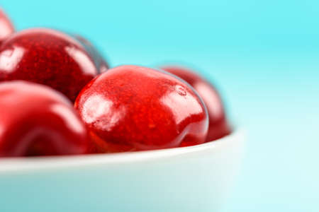 White Bowl Of Fresh Red Cherries On Turquoise Backgroundの写真素材