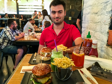BUCHAREST, ROMANIA - JUNE 09, 2016: People Eating Burgers, French Fries And Lemonade In Fast Food Restaurant.のeditorial素材