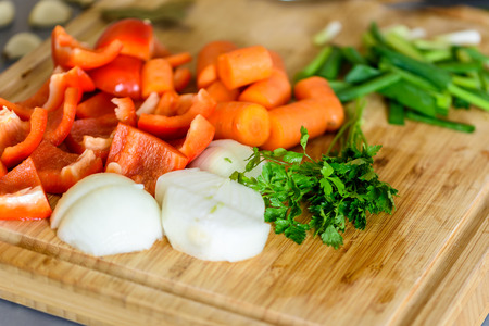Onion, Carrots, Bell Peppers, Garlic And Parsley Raw Vegetables Ingredients On Woodの写真素材