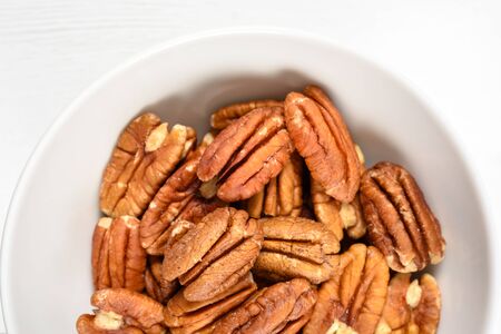 Pecan Nuts In White Bowl On Tableの写真素材