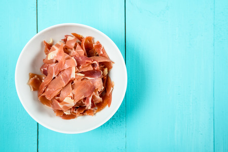 Fresh Bacon In White Bowl On Turquoise Tableの写真素材