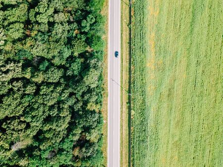 Aerial Drone View Of Moving Cars On Country Road With Forest And Agriculture Crop Field On Sidesの写真素材