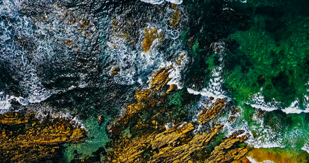 Aerial View From Flying Drone Of Ocean Waves Crushing On Rocky Beach Landscapeの写真素材