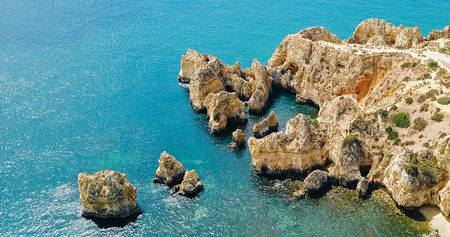 Aerial View From Flying Drone Of Calm Blue Water And Rocks Formations In Algarve Lagos, Portugal