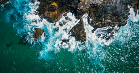 Aerial Drone View Of Dramatic Ocean Waves Crushing On Rocky Landscapeの写真素材