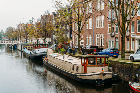 AMSTERDAM, NETHERLANDS - NOVEMBER 08, 2017: Common Dutch Houses and Houseboats On Amsterdam Canal In Autumnのeditorial素材