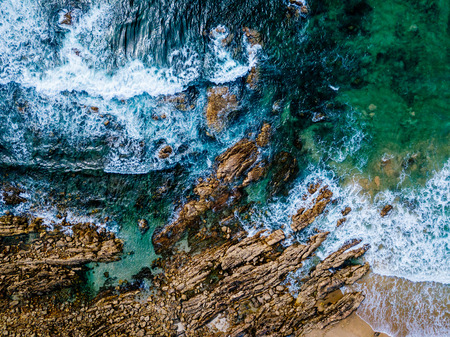 Aerial Drone View Of Dramatic Ocean Waves Crushing On Rocky Landscape