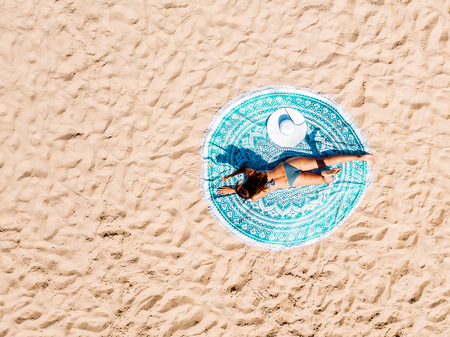 Top Aerial Drone View Of Woman In Swimsuit Bikini Relaxing And Sunbathing On Round Turquoise Beach Towel Near The Oceanの写真素材