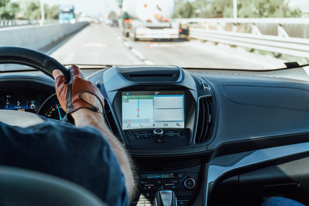Dashboard View And GPS Map Of Modern Car With Hands Of Man Driver On Steering Wheelの写真素材