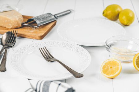 Restaurant Table Setup With Plates and Cutlery, Lemons And Parmesanの写真素材