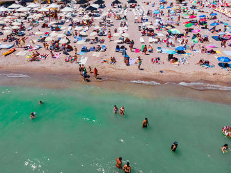 Aerial View Of People And Colorful Umbrellas On Ocean Seaside Beach In Summerの写真素材