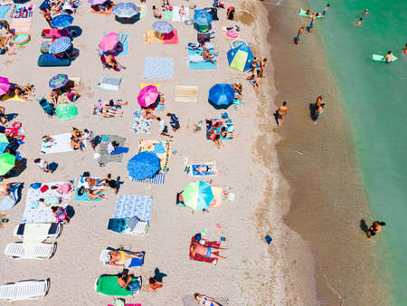 Aerial View Of People And Colorful Umbrellas On Ocean Seaside Beach In Summerの写真素材