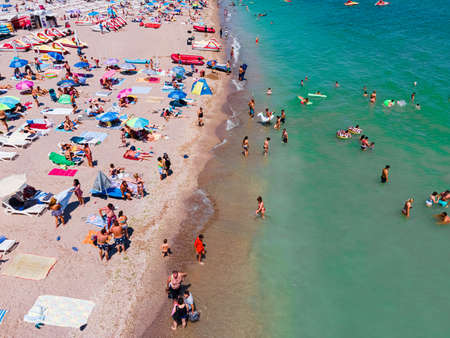 Aerial View Of People And Colorful Umbrellas On Ocean Seaside Beach In Summerの写真素材