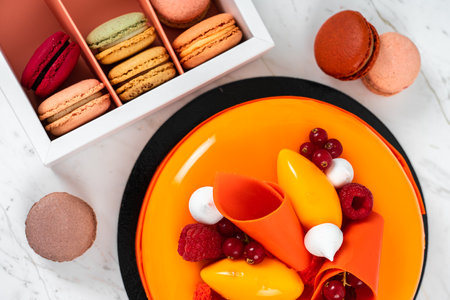 Orange, Mango, Raspberry Fruit Anniversary Birthday Cake and Colorful Homemade French Macaronsの写真素材