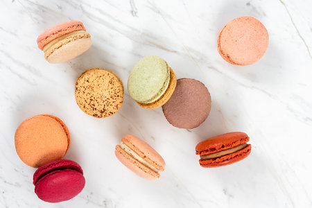 Colorful Fruity Macarons Flat Lay and Top View on White Marble Tableの写真素材
