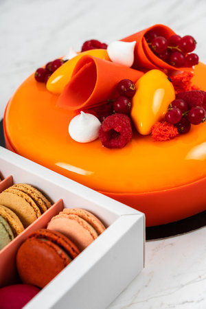Orange, Mango, Raspberry Fruit Anniversary Birthday Cake and Colorful Homemade French Macaronsの写真素材