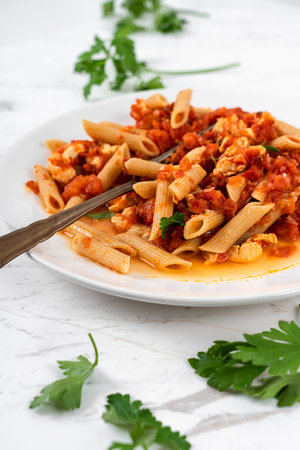 Pasta Penne, Tomato Sauce and Salmon on White Marble Table Backgroundの写真素材
