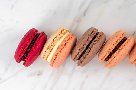 Colorful Fruity Macarons Flat Lay and Top View on White Marble Tableの写真素材