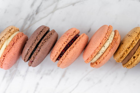 Colorful Fruity Macarons Flat Lay and Top View on White Marble Tableの写真素材