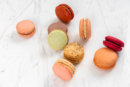 Colorful Fruity Macarons Flat Lay and Top View on White Marble Tableの写真素材