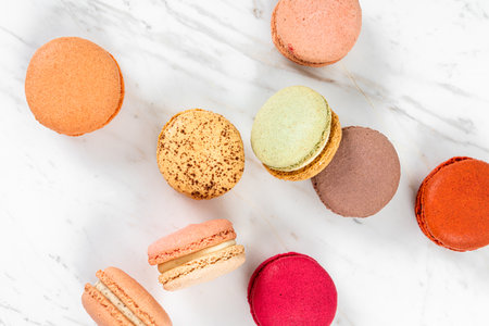 Colorful Fruity Macarons Flat Lay and Top View on White Marble Tableの写真素材