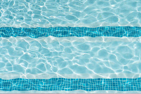Ripple Clear Blue Water in Swimming Pool with Sun Reflection Textureの写真素材