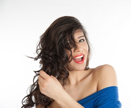 Beautiful brunette laughing and holding her hairの写真素材