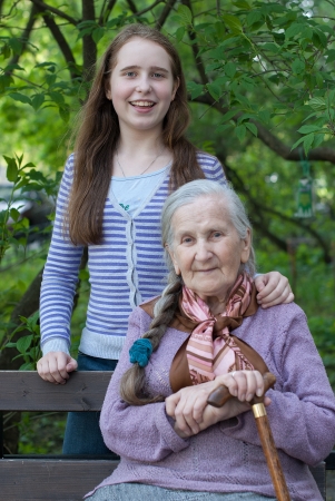 Grandmother and granddaughter laughing in the park in summerの写真素材