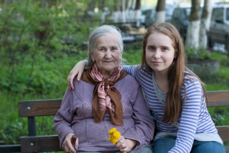 Grandmother and granddaughter laughing in the park in summerの写真素材