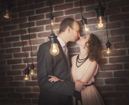 loving couple in the background of walls from a brick and light bulbsの写真素材