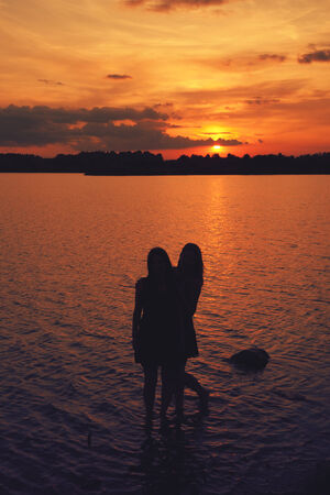 girlfriend on the beach having fun at sunset in summerの写真素材