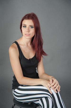 girl in a black vest and striped trousers greyの写真素材